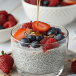 Chia pudding recipe topped with fresh strawberries, blueberries, and raspberries, drizzled with honey. A healthy and delicious breakfast or snack option.